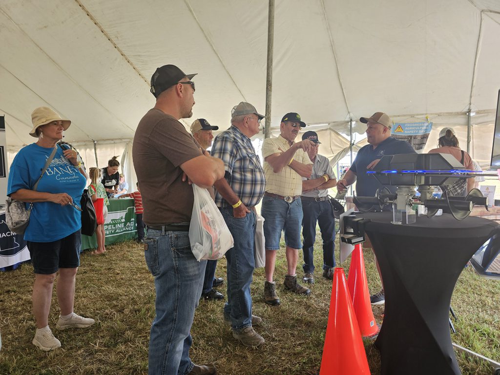Farmfest attendeess gather to watch the Grain Weevil presentation