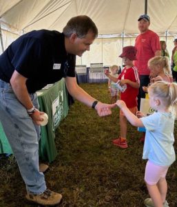 Kids interact with farm safety experts at UMASH farm safety pavilion tent.